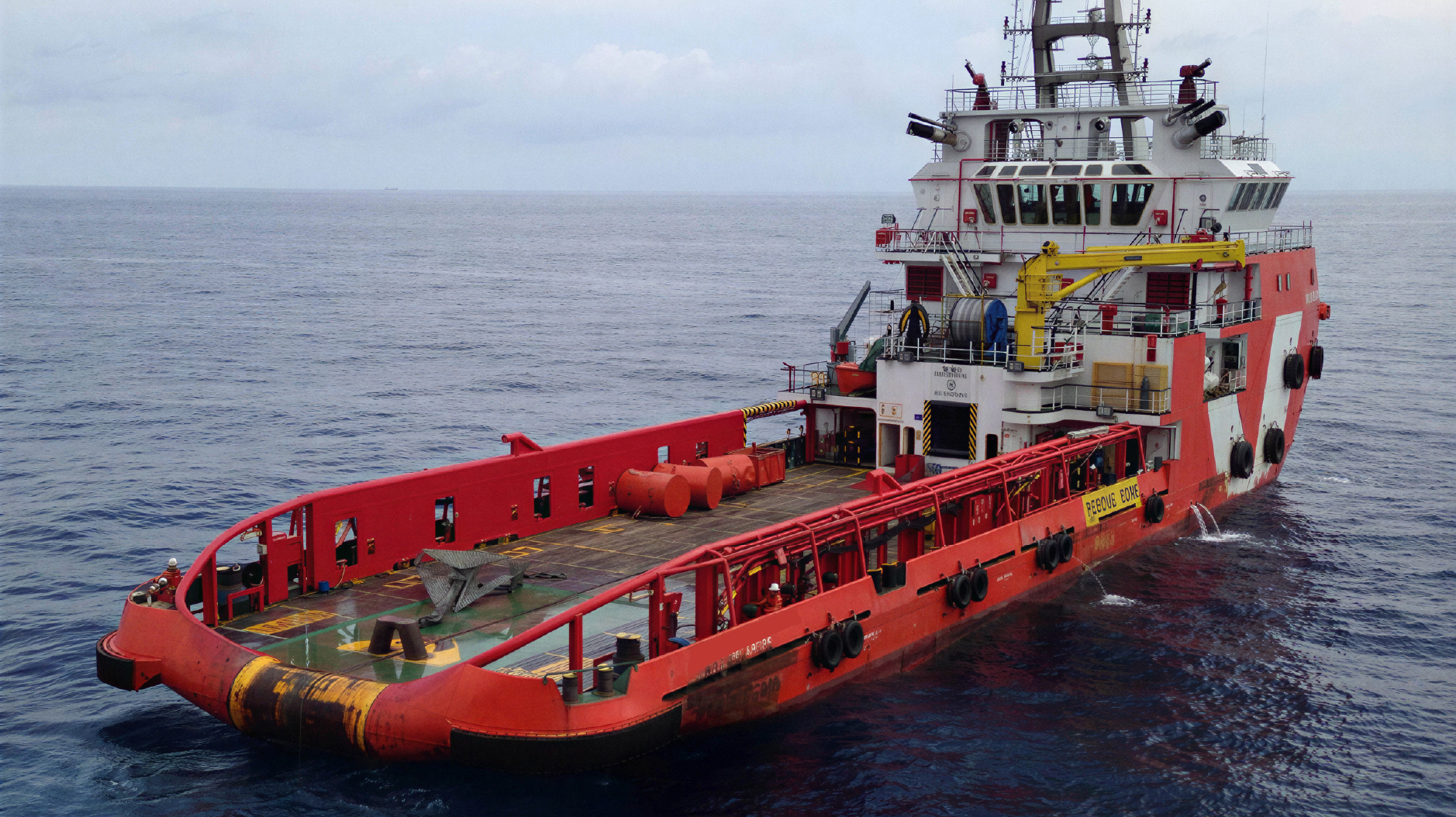 Offshore oil and gas platform at dusk, viewed from a support vessel